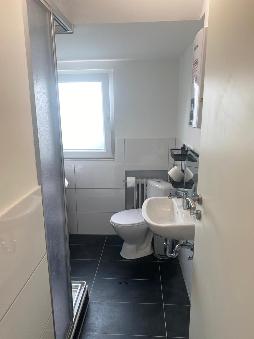 Helles Badezimmer mit Fenster, Dusche, WC und Waschbecken