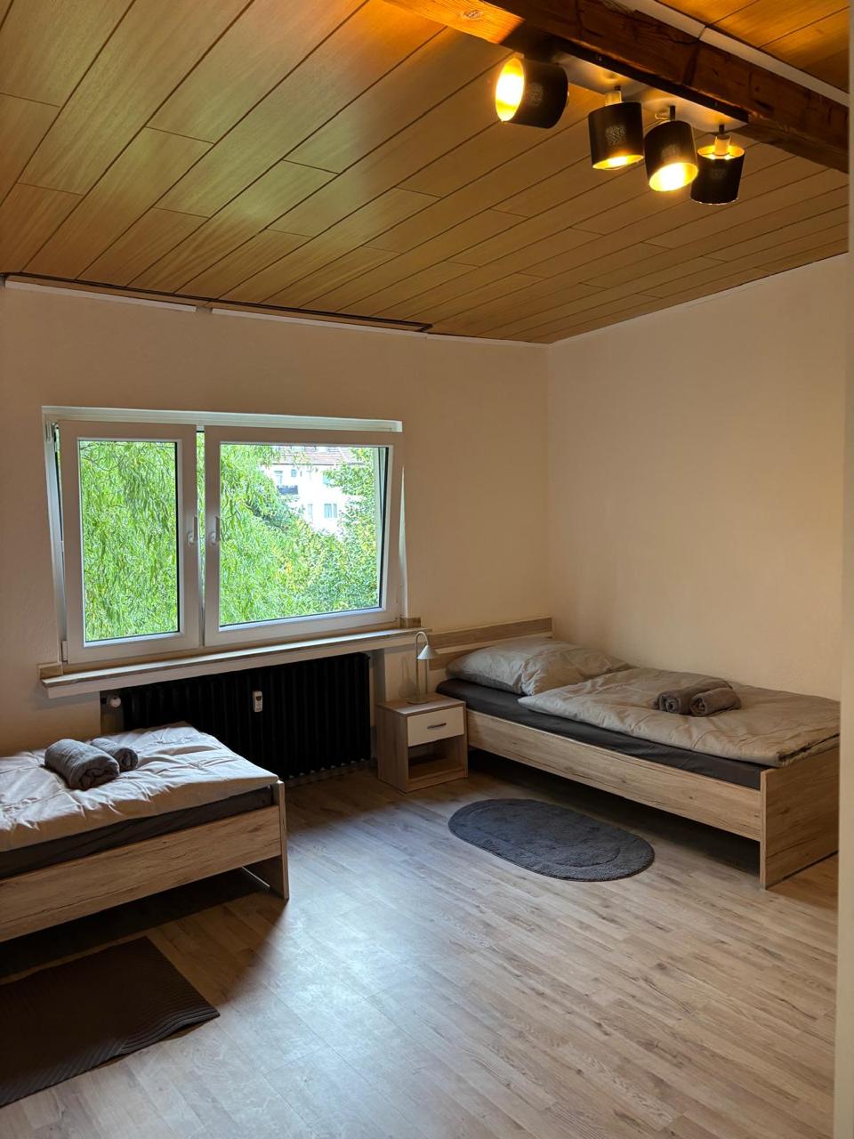 Mehrbettzimmer mit Fenster- und Bettansicht